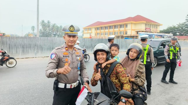 Kasat Lantas Polres Solok Kota, IPTU Rido, S.H., M.H., menyapa dan menyerahkan bendera Merah Putih kepada pengguna jalan dengan penuh keramahan. Warga tampak tersenyum bahagia sambil mengacungkan jempol, menjelang peringatan HUT Kemerdekaan RI ke-81.