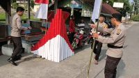 Personel Bhabinkamtibmas Polres Solok Kota bekerja sama memasang bendera Merah Putih dan menghias sudut jalan dengan warna kebangsaan jelang HUT Kemerdekaan RI ke-81.