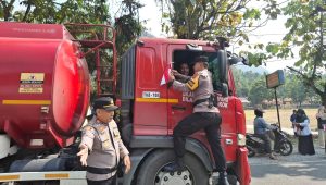 Kapolsek IX Koto Sungai Lasi, AKP Oon Kurnia Ilahi, memimpin langsung pembagian dan pemasangan bendera Merah Putih kepada pengendara di Jalan Lintas Sumatera.