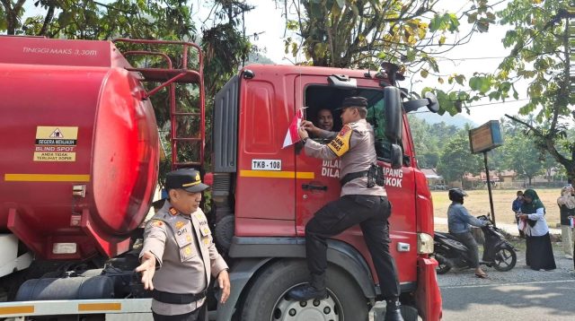 Kapolsek IX Koto Sungai Lasi, AKP Oon Kurnia Ilahi, memimpin langsung pembagian dan pemasangan bendera Merah Putih kepada pengendara di Jalan Lintas Sumatera.