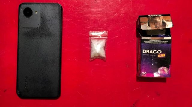 Barang bukti yang diamankan petugas, HP Realme, paket diduga sabu, serta kotak rokok Draco tempat menyembunyikan barang terlarang milik tersangka