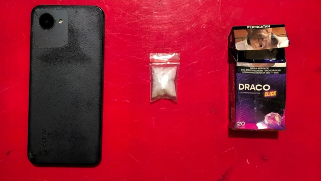 Barang bukti yang diamankan petugas, HP Realme, paket diduga sabu, serta kotak rokok Draco tempat menyembunyikan barang terlarang milik tersangka