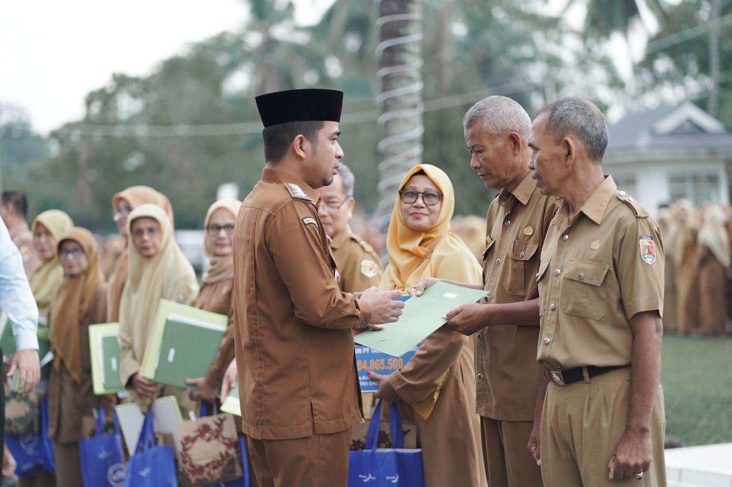 Wali Kota Solok Ramadhani Kirana Putra menyerahkan hadiah ibadah umrah kepada Sarmijan sebagai apresiasi atas pengabdiannya selama 41 tahun di lingkungan Disdukcapil Kota Solok.