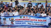 Semangat kebanggaan terpancar jelas! Jajaran pemimpin daerah, Ketua KONI Kota Solok, beserta para atlet kontingen Kota Solok berfoto bersama di depan spanduk kebanggaan bertuliskan "Maju dan Berprestasi".