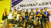 Satu tim, satu semangat! Para petarung Muaythai Kabupaten Solok berfoto penuh kebanggaan bersama pelatih dan pendamping usai menyapu bersih 10 medali di ajang Porprov XIV Sumbar 2026.