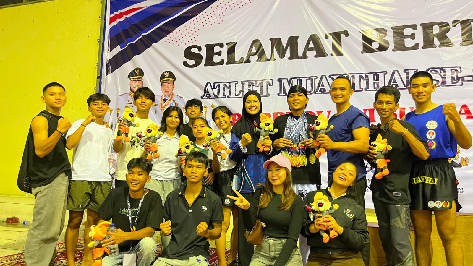 Satu tim, satu semangat! Para petarung Muaythai Kabupaten Solok berfoto penuh kebanggaan bersama pelatih dan pendamping usai menyapu bersih 10 medali di ajang Porprov XIV Sumbar 2026.